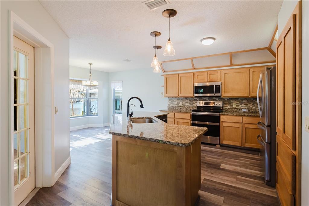 28330 Peterson Camp Road Brooksville, FL 34601 - Photo 15 of 81 a kitchen with stainless steel appliances granite countertop a stove a sink and a refrigerator