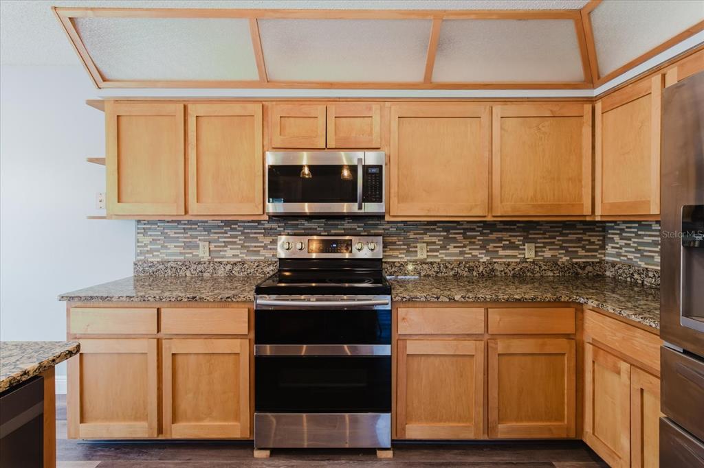 28330 Peterson Camp Road Brooksville, FL 34601 - Photo 20 of 81 a kitchen with stainless steel appliances granite countertop a stove microwave and cabinets