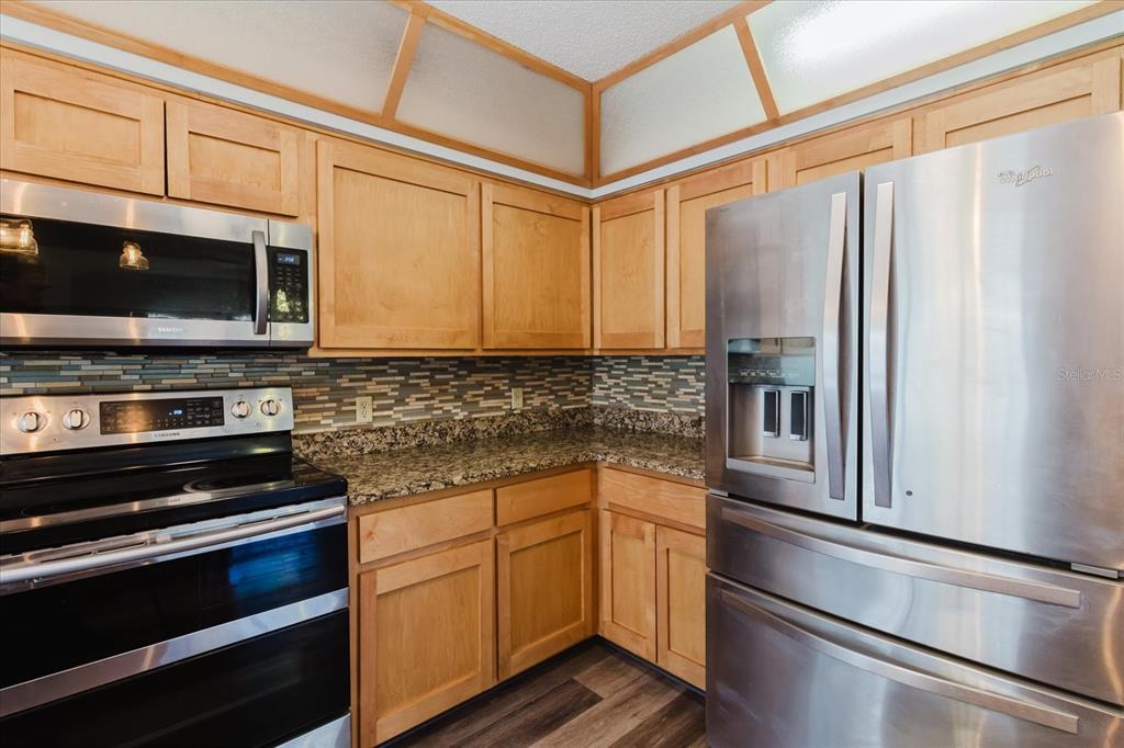 28330 Peterson Camp Road Brooksville, FL 34601 - Photo 21 of 81 a kitchen with stainless steel appliances a refrigerator stove and microwave
