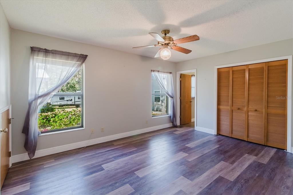 28330 Peterson Camp Road Brooksville, FL 34601 - Photo 28 of 81 a view of an empty room with window wooden floor and a ceiling fan