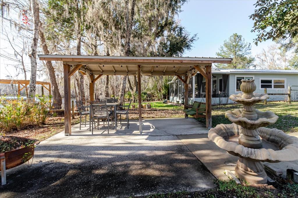 28330 Peterson Camp Road Brooksville, FL 34601 - Photo 68 of 81 a view of a patio with couches chairs and a potted plants