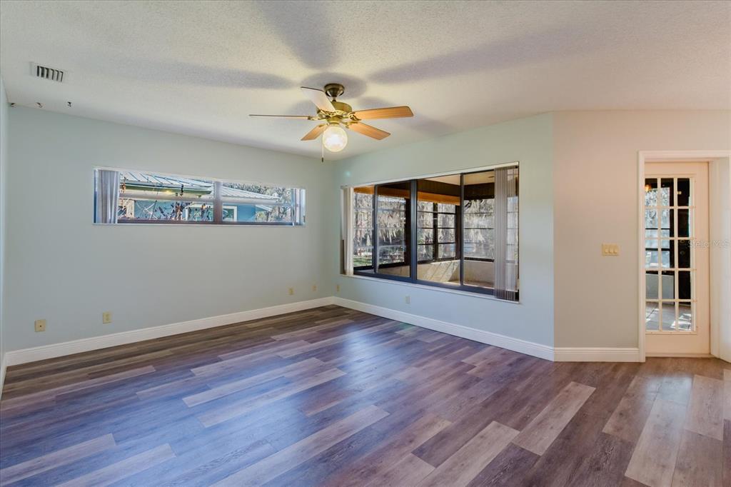 28330 Peterson Camp Road Brooksville, FL 34601 - Photo 10 of 81 a view of an empty room with a window and wooden floor