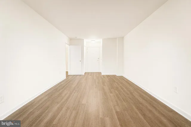 a view of empty room with wooden floor