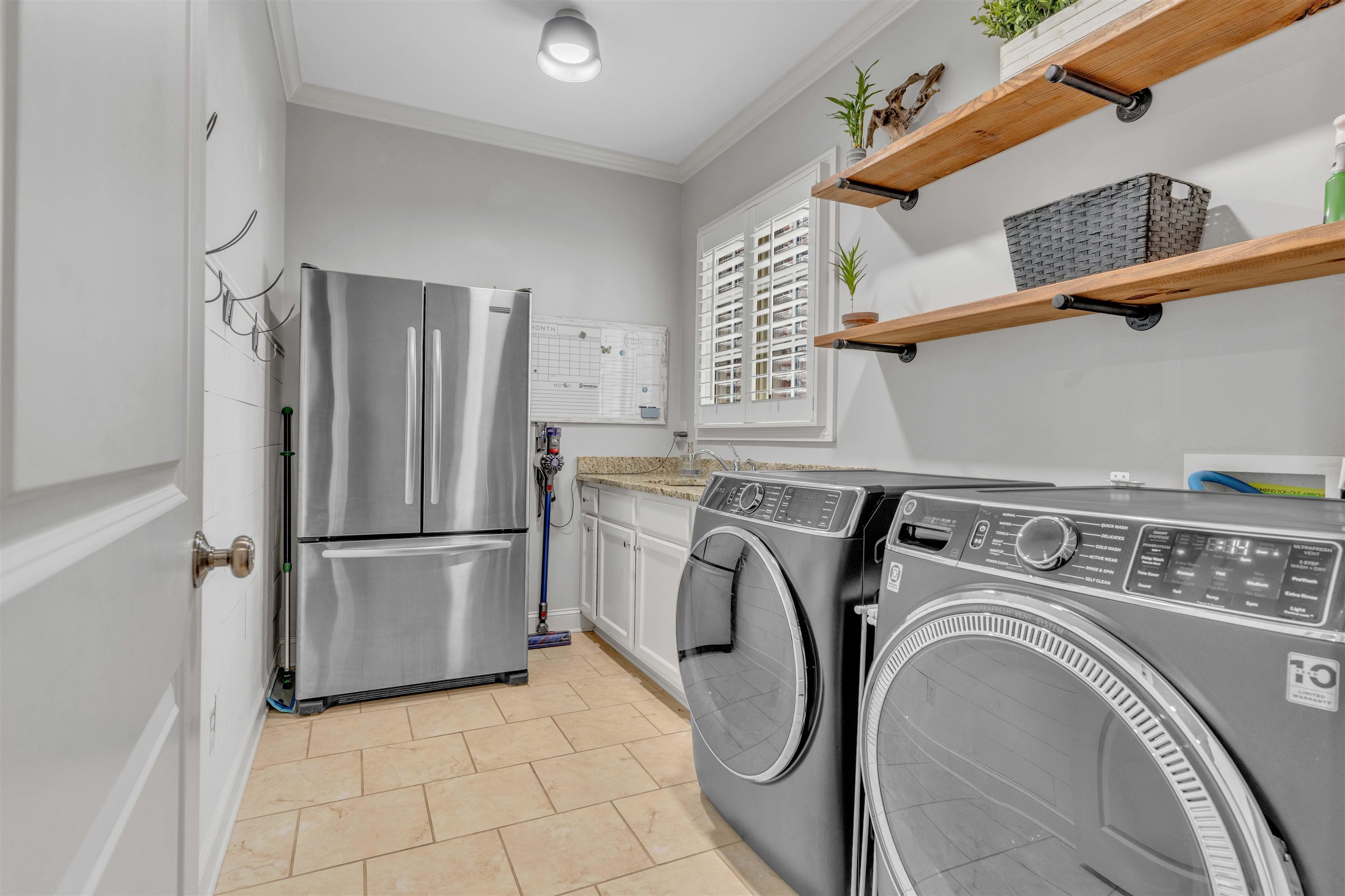 528 Althea Lane Collierville, TN 38017 - Photo 17 of 36 Laundry room featuring ornamental molding, washing machine and dryer, and light tile patterned flooring