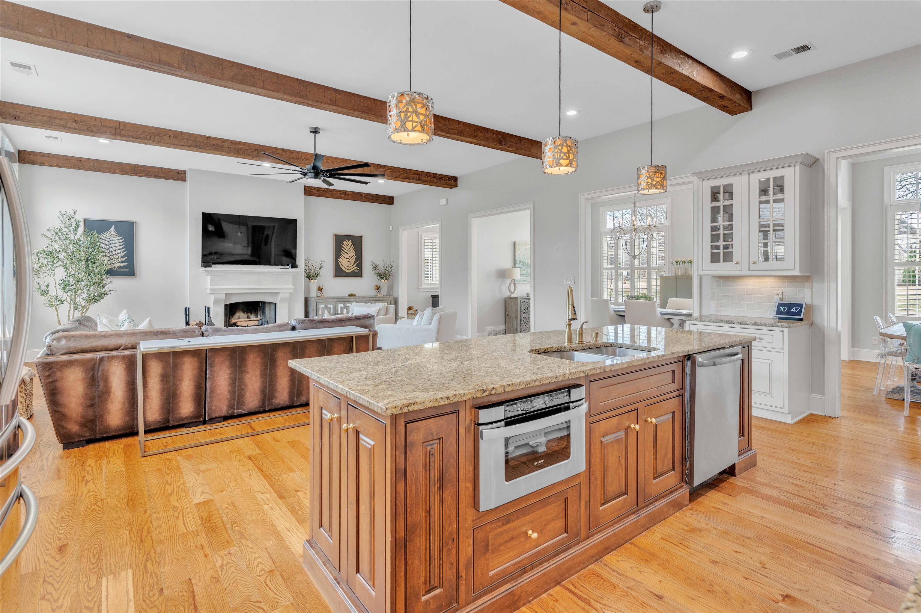 528 Althea Lane Collierville, TN 38017 - Photo 36 of 36 Kitchen with open floor plan, glass insert cabinets, light stone countertops, a fireplace, and an island with sink
