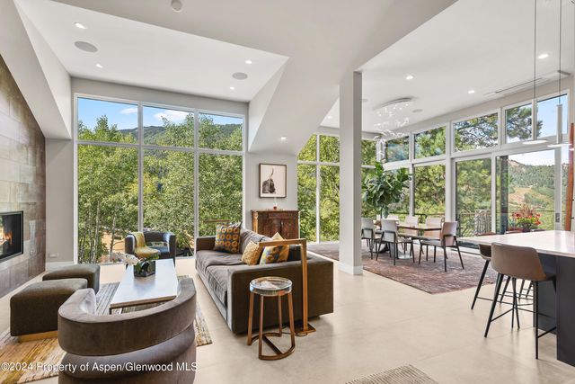 a dining room with stainless steel appliances a table and chairs with potted plants