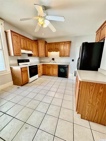 a kitchen with stainless steel appliances a stove a sink a microwave a refrigerator a counter top space and cabinets