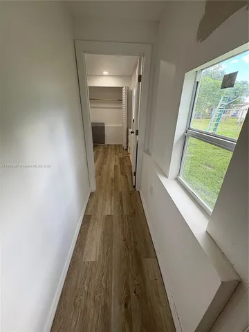 a view of hallway with wooden floor and stairs