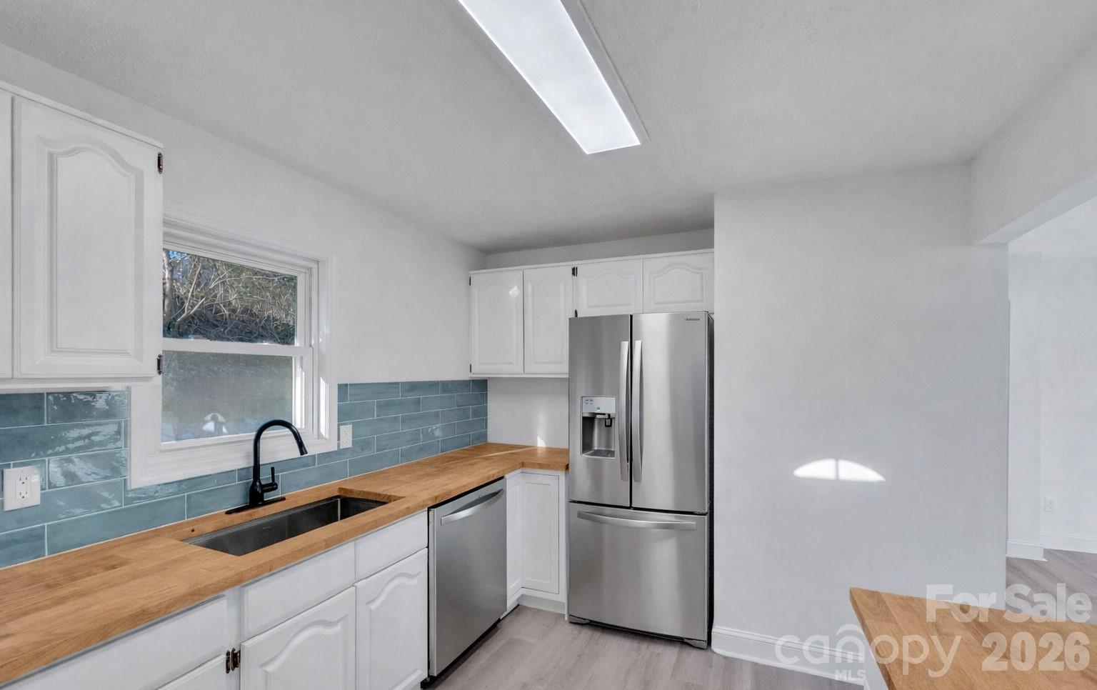 49 East Livingston Street Tryon, NC 28782 - Photo 5 of 27 a kitchen with stainless steel appliances granite countertop a refrigerator and a sink