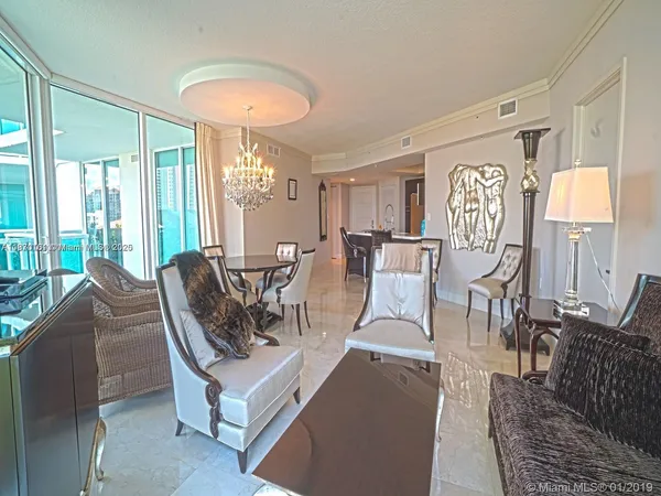 a living room with furniture a chandelier and a dining table