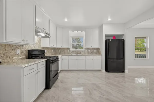 a kitchen with a refrigerator a sink and a microwave