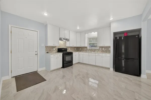 a kitchen with granite countertop white cabinets and white appliances