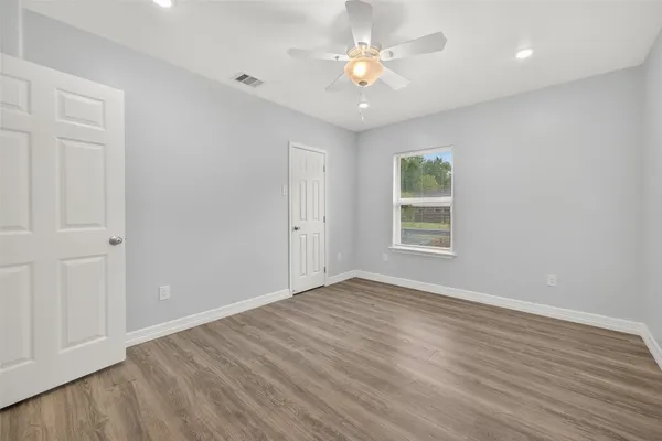 wooden floor in an empty room with a window