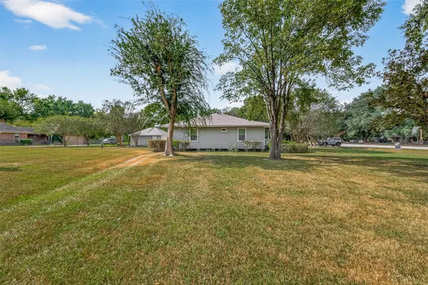 a view of a house with backyard and trees