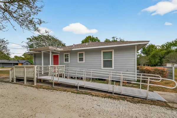 a view of a house with a backyard and a chair