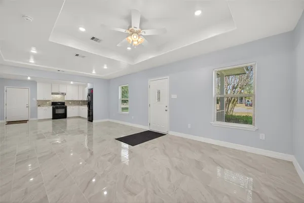 a view of an empty room with window and cabinet