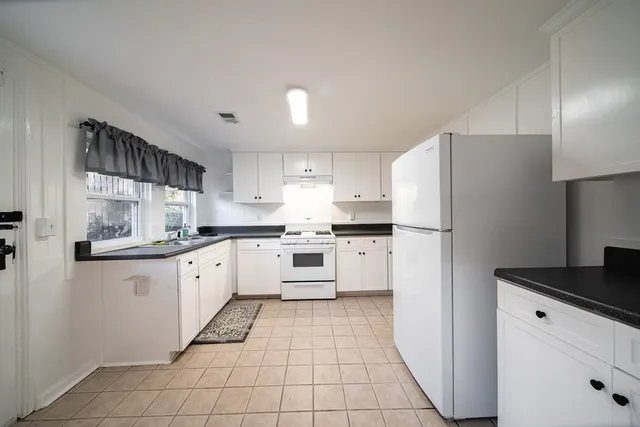 a kitchen with cabinets and white stainless steel appliances