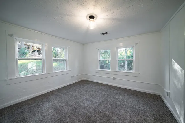 a view of a big room with windows and chandelier fan