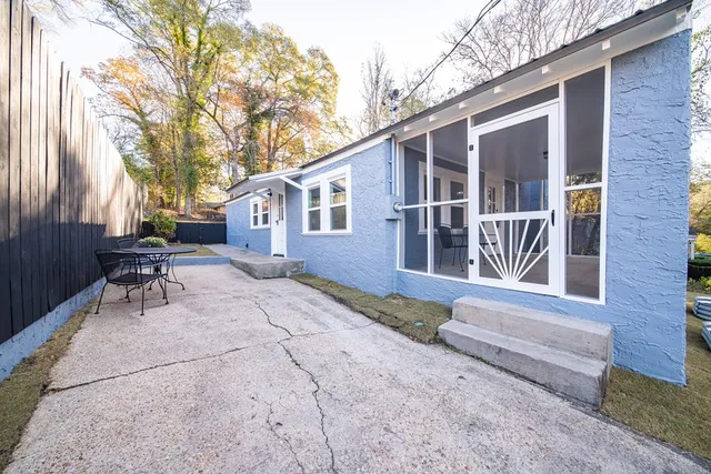 a view of house with backyard and outdoor seating