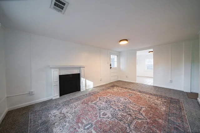 a view of an empty room and a fireplace