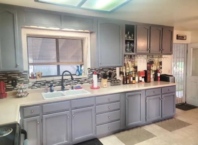 a kitchen with stainless steel appliances granite countertop a table chairs sink and cabinets