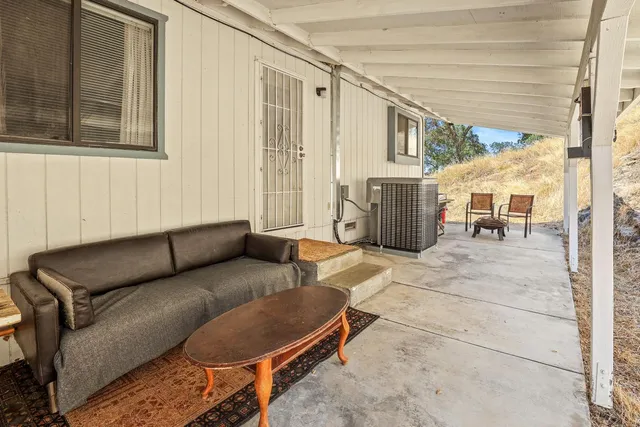 an aerial view of a house with a yard and trees all around