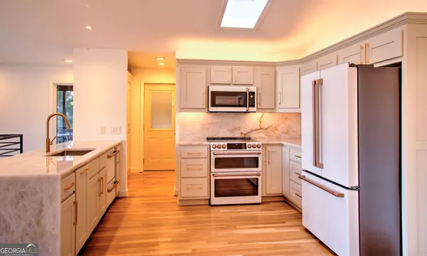 a kitchen with stainless steel appliances a refrigerator stove and sink