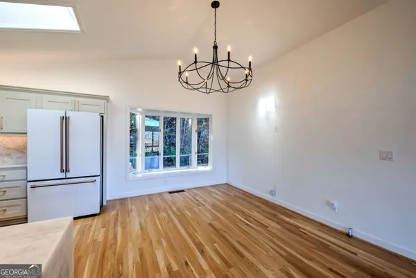 a view of empty room with wooden floor and windows