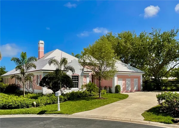 a front view of a house with a yard and potted plants