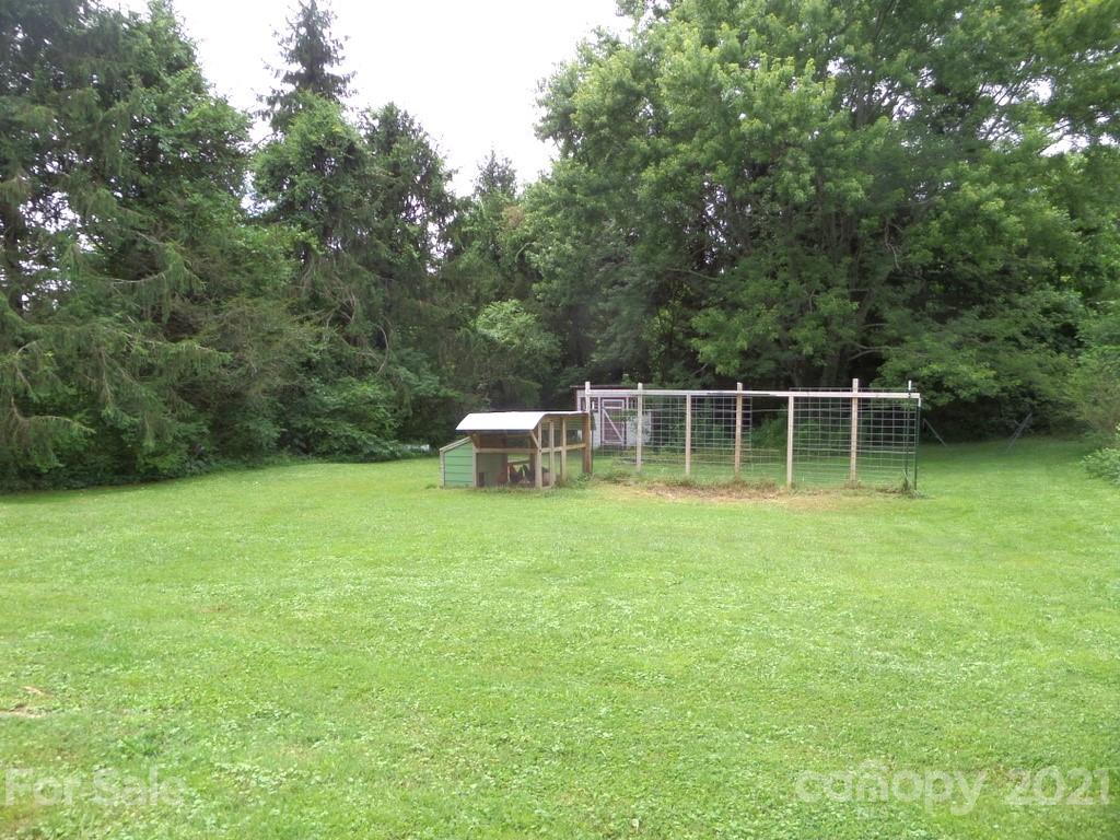 499 Oak Grove Road Flat Rock, NC 28731 - Photo 7 of 18 a backyard of a house with outdoor seating and trees