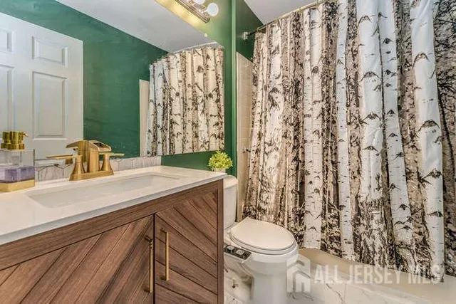 a bathroom with a sink a toilet and shower curtain