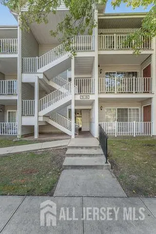a view of a brick house with a small yard and wooden fence