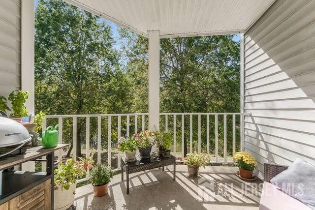 a balcony with potted plants and white walls