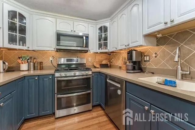 a kitchen with stainless steel appliances wooden cabinets and a stove top oven
