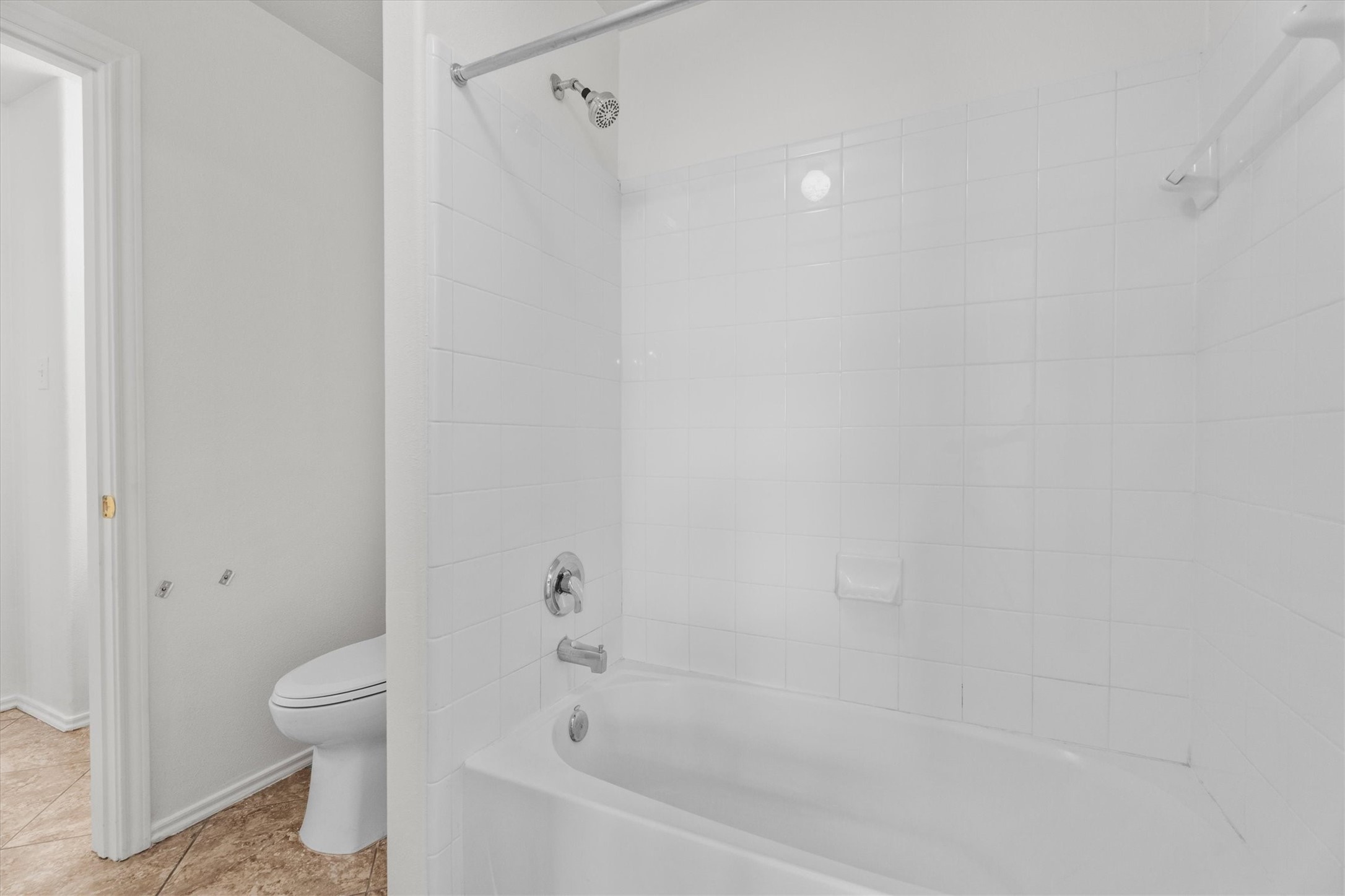 2507 Grayfeather Court Spring, TX 77388 - Photo 22 of 37 Secondary white-tiled bathroom featuring a shower-tub combo and a toilet with a tiled floor.