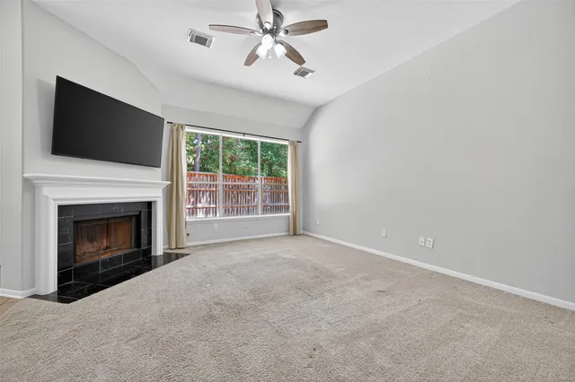 a view of empty room with fireplace and fan
