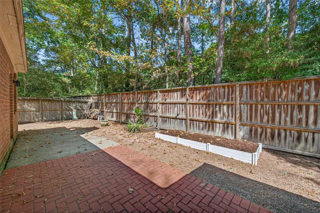 a view of a backyard with a large tree and wooden fence