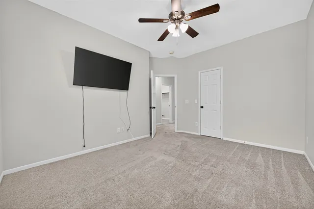 an empty room with fan and windows