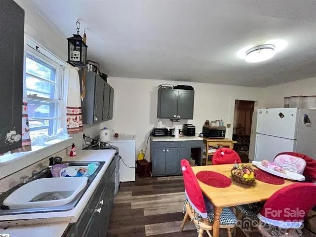 a very nice looking kitchen with granite countertop a dining table chairs stove a sink and dishwasher