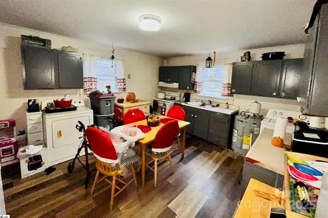 a very nice looking open kitchen with stainless steel appliances granite countertop a sink dishwasher a dining table and chairs with wooden floor