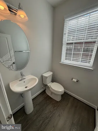 a bathroom with a toilet a sink and mirror