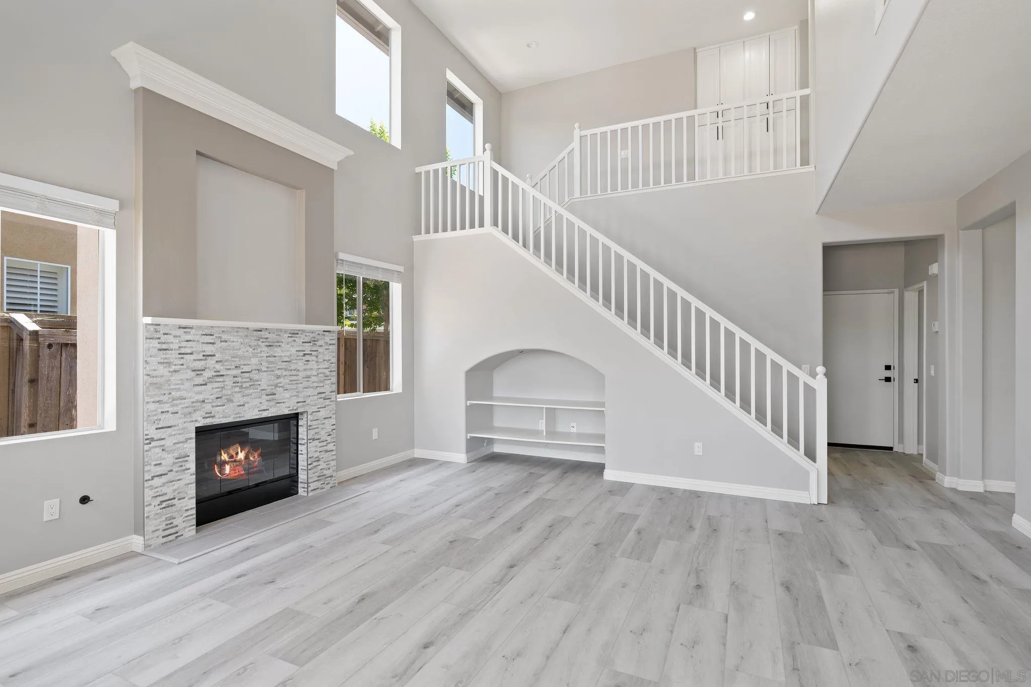 11576 Village Ridge Road San Diego, CA 92131 - Photo 9 of 20 a view of a livingroom with wooden floor a fireplace and entryway