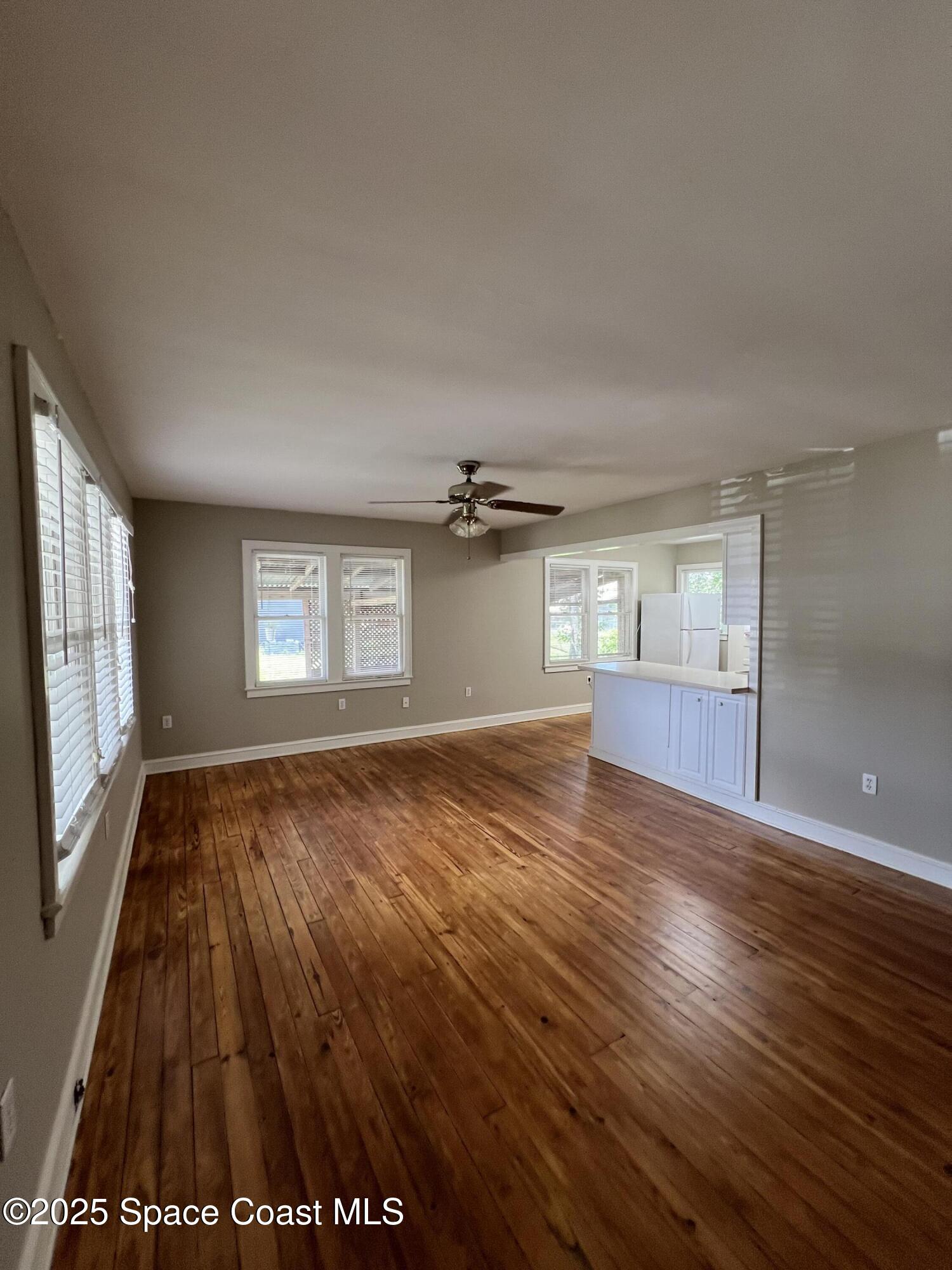 6500 June Drive Cocoa, FL 32926 - Photo 5 of 21 an empty room with wooden floor and windows