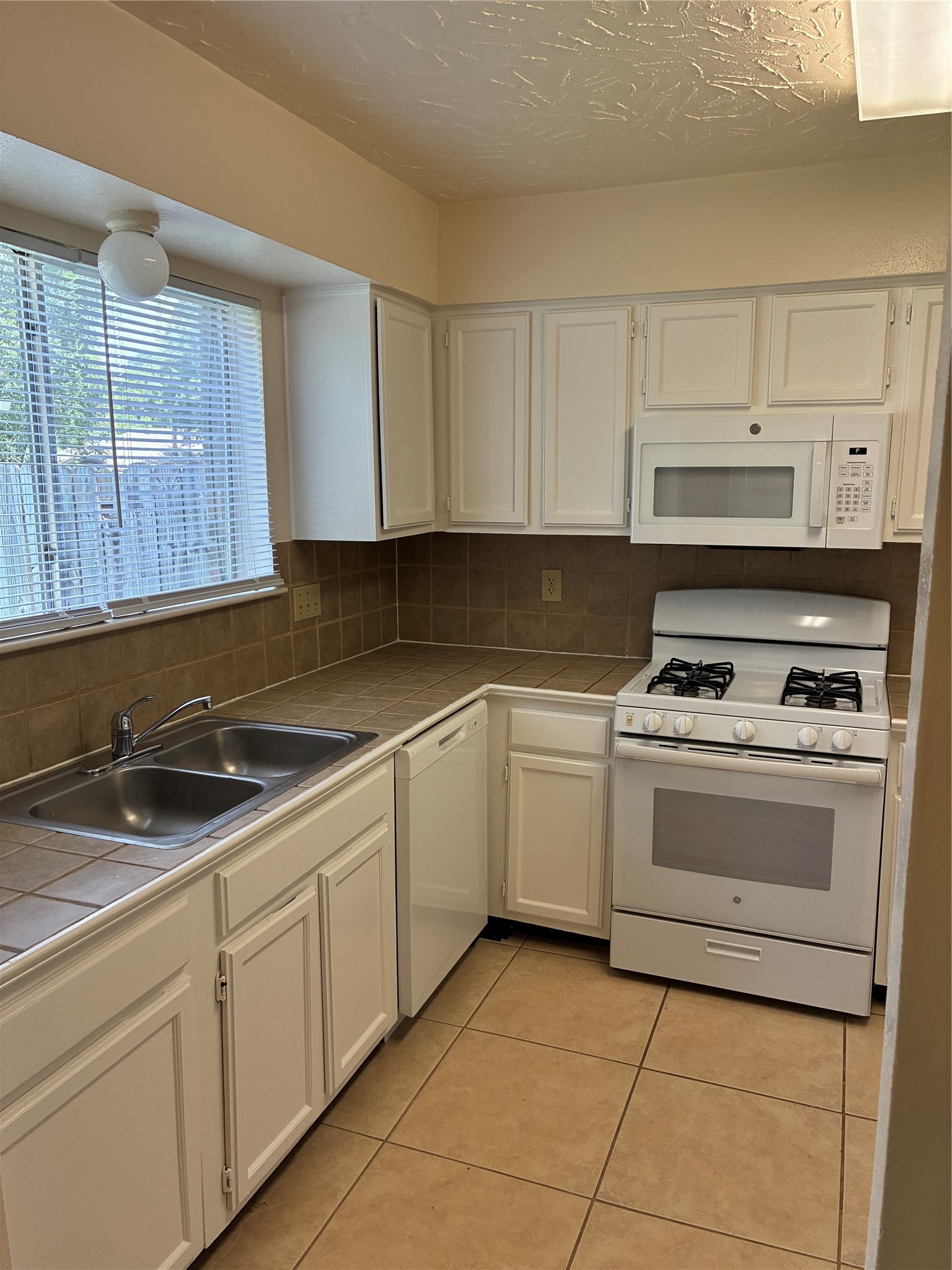 16230 Cutten Road Houston, TX 77070 - Photo 9 of 25 a kitchen with cabinets appliances and a sink