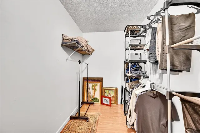 a view of walk in closet with clothes and shoes