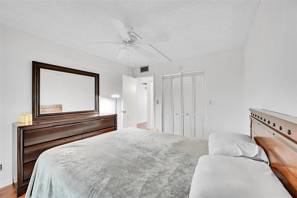 1901 Bermuda Circle, Unit L3 Coconut Creek, FL 33066 - Photo 20 of 27 a bedroom with a bed and a chandelier