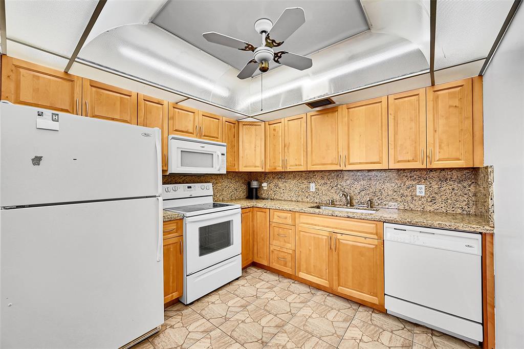 1901 Bermuda Circle, Unit L3 Coconut Creek, FL 33066 - Photo 2 of 27 a kitchen with stainless steel appliances granite countertop a refrigerator a sink a stove and white cabinets