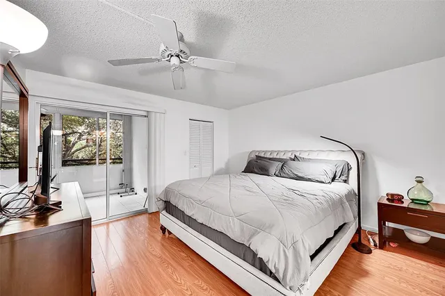 a bedroom with a bed and large mirror with wooden floor