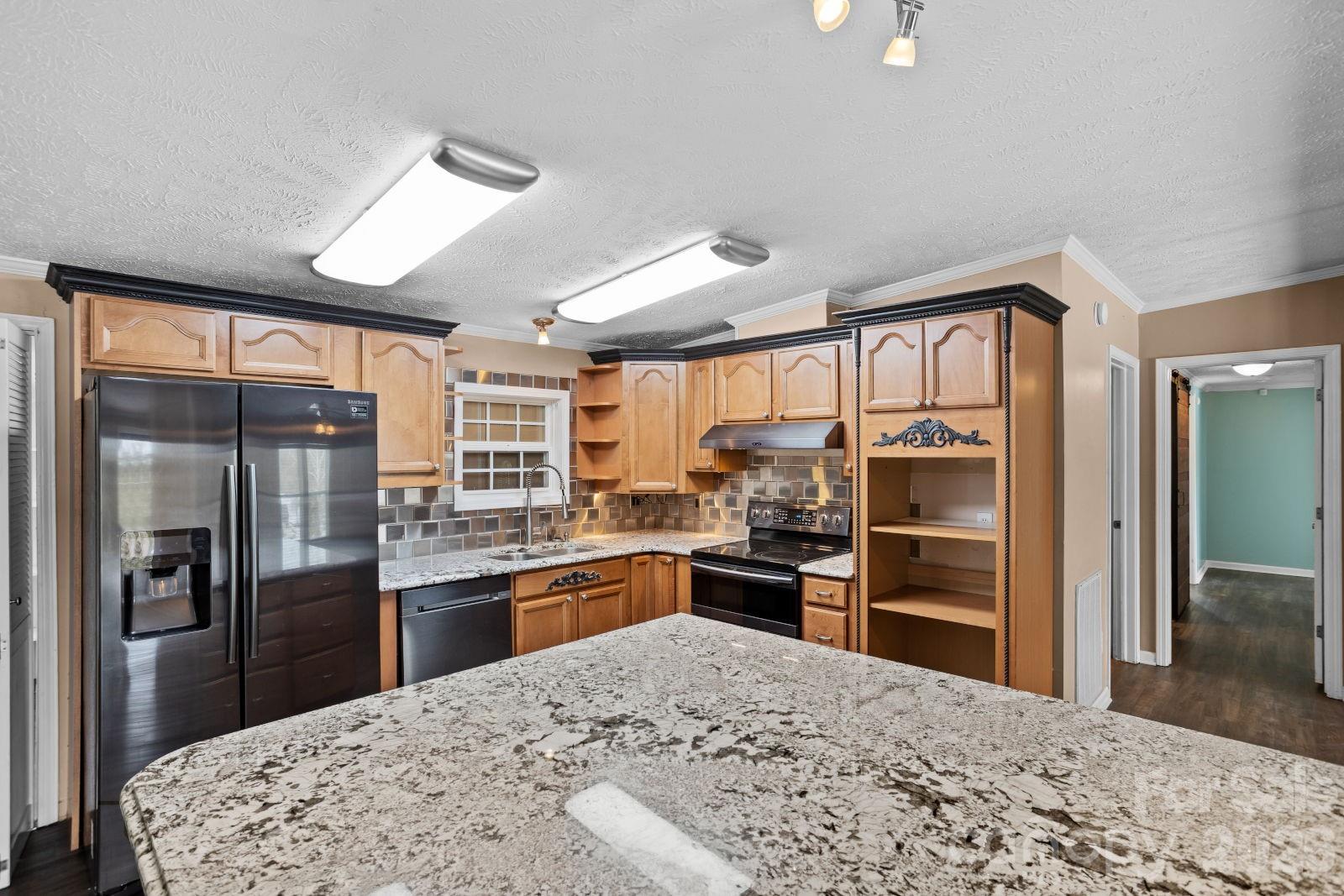4855 Talley Road Walkertown, NC 27051 - Photo 16 of 45 a kitchen with granite countertop a refrigerator and a sink
