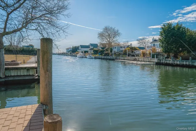 a view of a lake with a floor to ceiling window and potted plants
